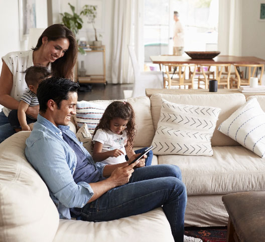 Family of 4 people gathered together in their living room
